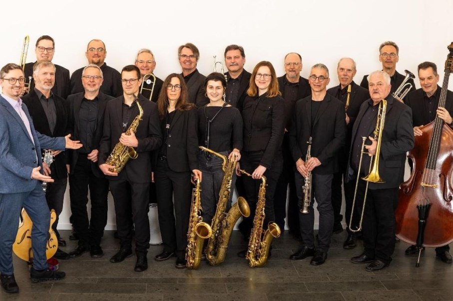 Eine Bigband in schwarzer Kleidung posiert mit Instrumenten wie Saxophonen, Trompeten und einem Kontrabass vor einem wei&szlig;en Hintergrund., &copy; Kulturzentrum Dieselstrasse