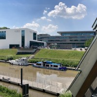 Moderne Gebäude am Flussufer in Remseck am Neckar, mit Booten im Wasser und einem klaren Himmel im Hintergrund., © Remstal Tourismus e. V.