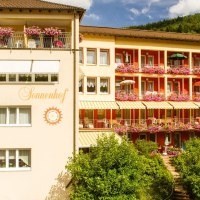Das Hotel Sonnenhof zeigt eine Fassade mit blühenden Balkonen und Sonnenschirmen. Der Schriftzug 'Sonnenhof' ist sichtbar. Im Hintergrund sind Bäume zu sehen., © Hotel Sonnenhof Das Hotel Sonnenhof zeigt eine Fassade mit blühenden Balkonen und Sonnenschirmen. Der Schriftzug 'Sonnenhof' ist sichtbar. Im Hintergrund sind Bäume zu sehen., © Hotel Sonnenhof