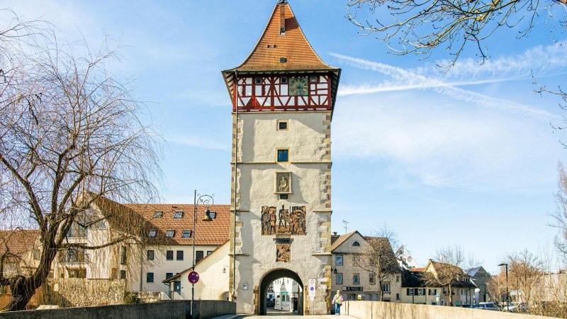 Das Beinsteiner Tor in Waiblingen, ein historisches Stadttor mit Fachwerk und Uhr, umgeben von Bäumen und blauen Himmel., © SMG, Sarah Schmid Das Beinsteiner Tor in Waiblingen, ein historisches Stadttor mit Fachwerk und Uhr, umgeben von Bäumen und blauen Himmel., © SMG, Sarah Schmid