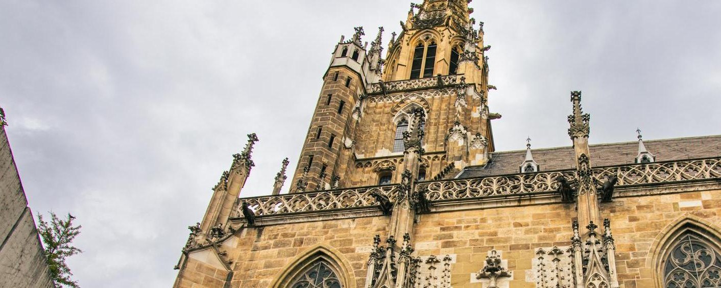 Die Frauenkirche in Esslingen zeigt ihre beeindruckende gotische Architektur mit verzierten T&uuml;rmen und Fenstern unter einem bew&ouml;lkten Himmel., &copy; Stuttgart-Marketing GmbH, Sarah Schmid
