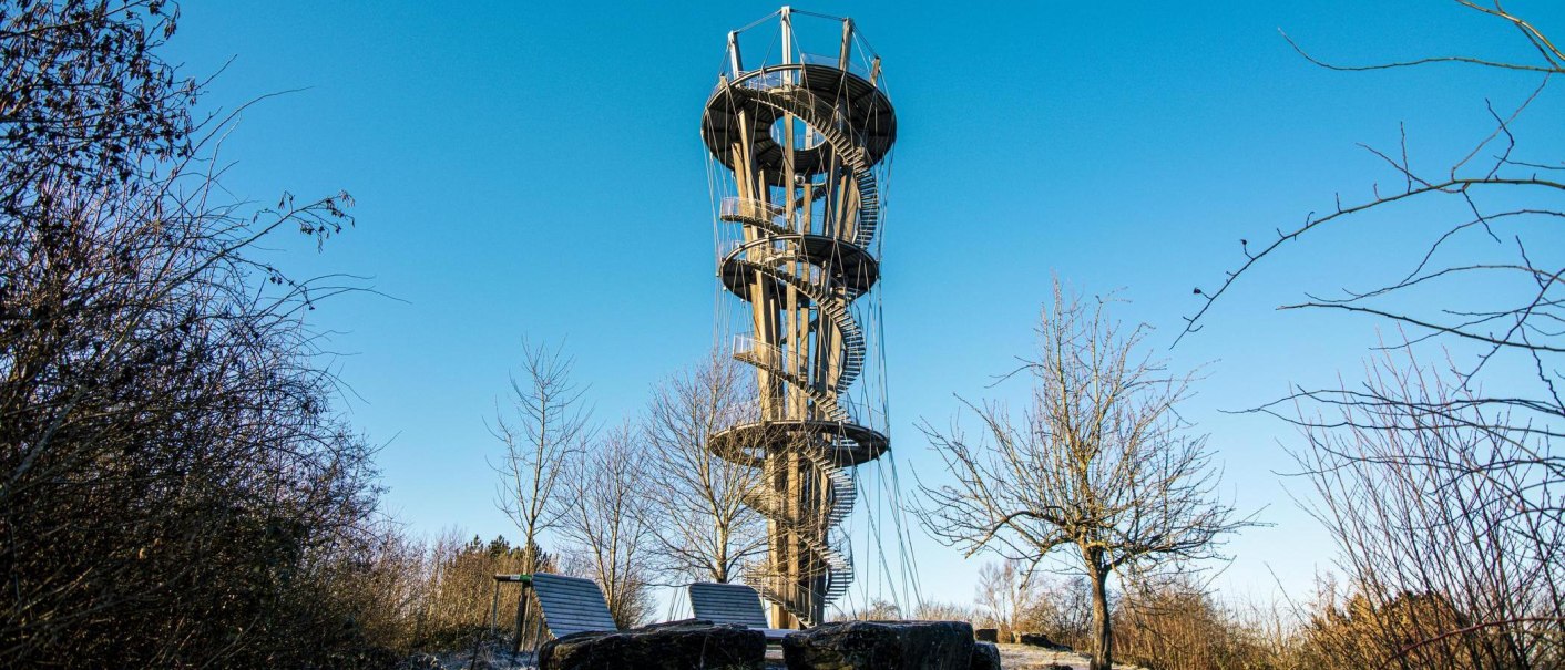 Der Schönbuchturm in Herrenberg erhebt sich vor einem klaren blauen Himmel, umgeben von kahlen Bäumen und winterlicher Landschaft., © SMG, Sarah Schmid Der Schönbuchturm in Herrenberg erhebt sich vor einem klaren blauen Himmel, umgeben von kahlen Bäumen und winterlicher Landschaft., © SMG, Sarah Schmid