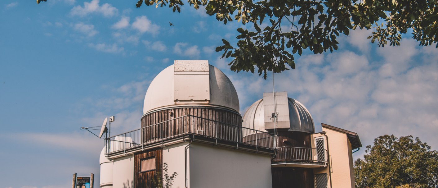 Ein Observatorium mit zwei Kuppeln steht auf einem Hügel unter blauem Himmel. Bäume rahmen das Bild ein., © Stadt Welzheim Ein Observatorium mit zwei Kuppeln steht auf einem Hügel unter blauem Himmel. Bäume rahmen das Bild ein., © Stadt Welzheim