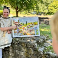 Eine Frau in r&ouml;mischer Kleidung zeigt Kindern ein Bild mit einer r&ouml;mischen Szene. Sie sitzt auf einer Steinmauer im Freien., &copy; Stadt N&uuml;rtingen