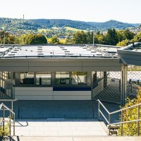 Moderner Eingangsbereich eines Freibads in Gaildorf, umgeben von grüner Landschaft und Hügeln im Hintergrund., © Stuttgart-Marketing GmbH, Sarah Schmid Moderner Eingangsbereich eines Freibads in Gaildorf, umgeben von grüner Landschaft und Hügeln im Hintergrund., © Stuttgart-Marketing GmbH, Sarah Schmid