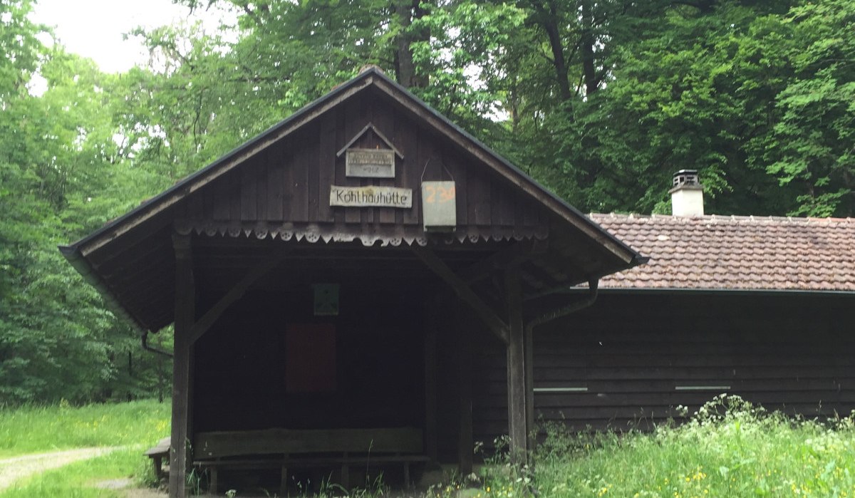 Holzhütte im Wald, beschriftet mit 'Kohlhauhütte', umgeben von grüner Wiese und Bäumen., © www.pro-cycl.de