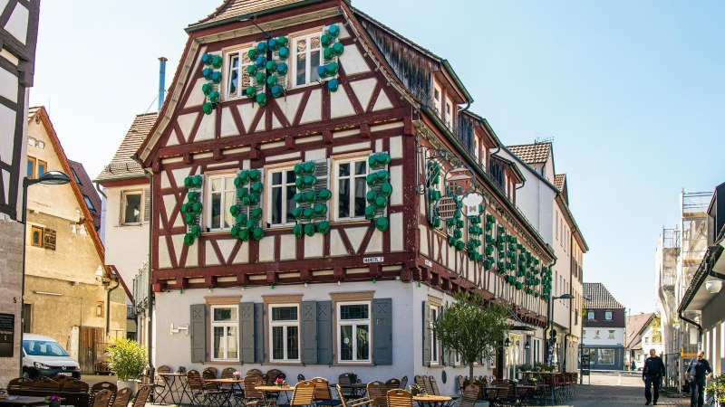 Fachwerkhaus in Kirchheim unter Teck mit grünen Fensterläden. Vor dem Gebäude stehen Tische und Stühle eines Straßencafés., © Stuttgart-Marketing GmbH, Sarah Schmid Fachwerkhaus in Kirchheim unter Teck mit grünen Fensterläden. Vor dem Gebäude stehen Tische und Stühle eines Straßencafés., © Stuttgart-Marketing GmbH, Sarah Schmid
