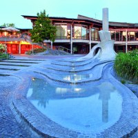 Modernes Bürgerzentrum mit beleuchteter Terrasse, geschwungenem Wasserlauf und gepflegter Gartenanlage bei Dämmerung., © WTM GmbH Waiblingen
