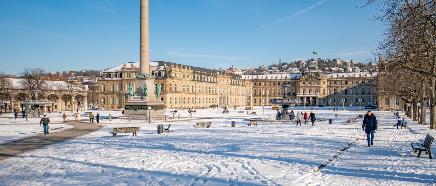 Schlossplatz Stuttgart im Winter, bedeckt mit Schnee. Menschen spazieren, die Sonne scheint, und das Neue Schloss ist im Hintergrund sichtbar., © SMG Thomas Niedermüller
