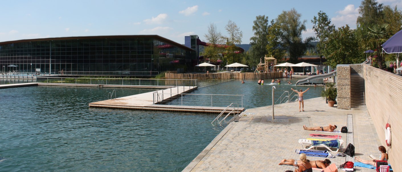 Das Oskar Frech Ziegelei SeeBad mit großem Schwimmbecken, Liegeflächen und Besuchern unter blauem Himmel., © Oskar Frech SeeBad Das Oskar Frech Ziegelei SeeBad mit großem Schwimmbecken, Liegeflächen und Besuchern unter blauem Himmel., © Oskar Frech SeeBad