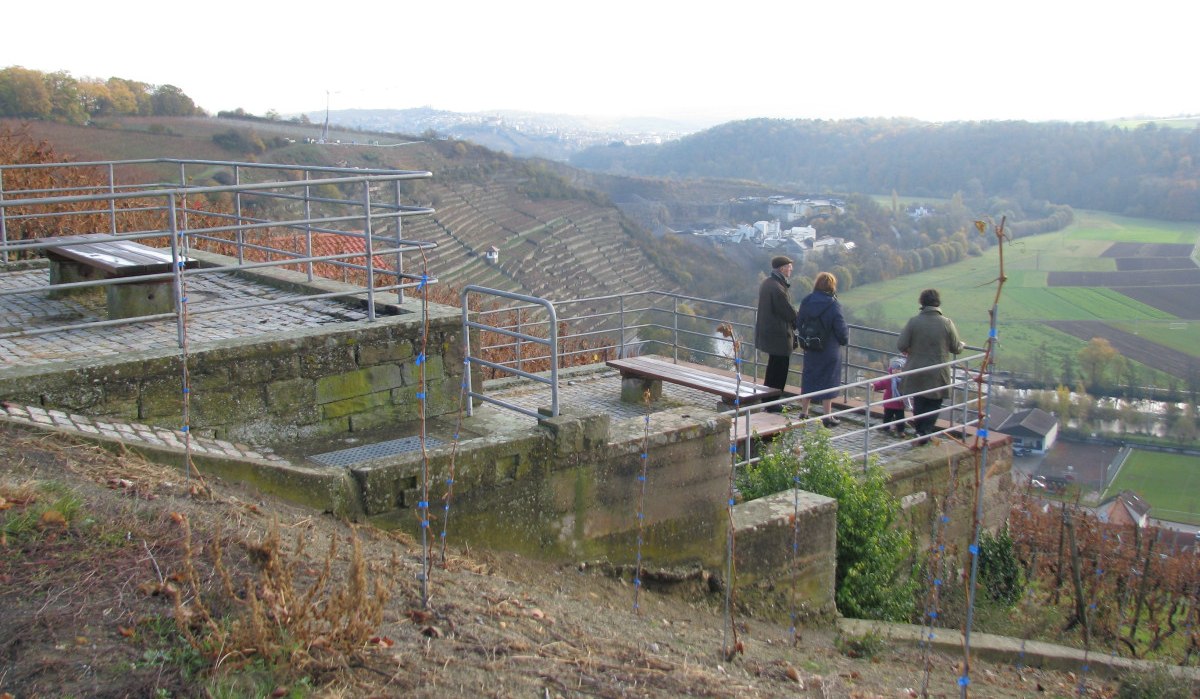 Menschen stehen auf einer Aussichtsplattform und blicken auf Weinberge und eine weite Landschaft. Herbstliche Farben dominieren die Szene., © Land der 1000 Hügel - Kraichgau-Stromberg