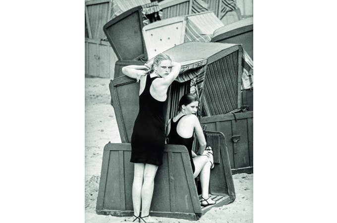 Zwei Frauen in Badeanz&uuml;gen posieren vor ge&ouml;ffneten Strandk&ouml;rben an einem sandigen Strand., &copy; Kunsthalle G&ouml;ppingen