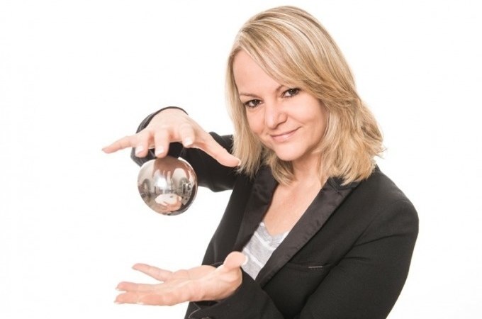 Frau mit blonden Haaren hält eine Glaskugel in den Händen und lächelt. Sie trägt einen schwarzen Blazer vor weißem Hintergrund., © Cool-Tours StattReisen Frau mit blonden Haaren hält eine Glaskugel in den Händen und lächelt. Sie trägt einen schwarzen Blazer vor weißem Hintergrund., © Cool-Tours StattReisen