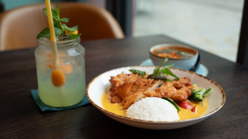 Ein Teller mit Reis, frittiertem H&auml;hnchen und Gem&uuml;se in Curryso&szlig;e. Daneben ein erfrischendes Getr&auml;nk mit Minze in einem Glas., &copy; Lunar