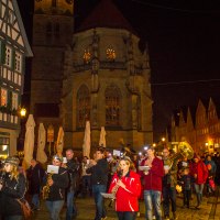 Menschen ziehen mit Blasinstrumenten bei Nacht durch Schorndorf. Im Hintergrund ist eine beleuchtete Kirche zu sehen., &copy; Stefanie Julia Heinrich