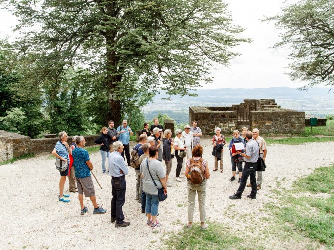 Gruppe bei einer Führung auf dem Hohenstaufen, umgeben von Bäumen und alten Mauern, mit Blick auf die Landschaft., © Stadt Göppingen Gruppe bei einer Führung auf dem Hohenstaufen, umgeben von Bäumen und alten Mauern, mit Blick auf die Landschaft., © Stadt Göppingen