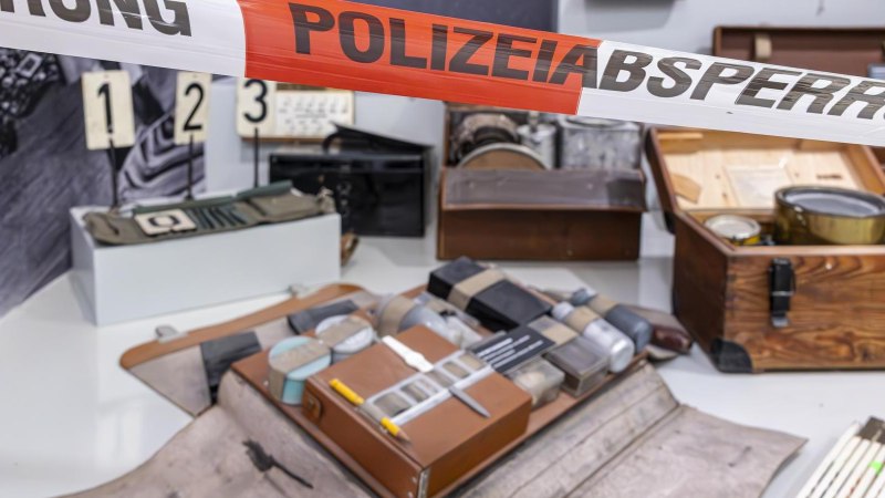 Ausstellungsstücke im Polizeimuseum Stuttgart, darunter alte Polizeiausrüstung und Beweismaterial, hinter einem Absperrband mit der Aufschrift 'POLIZEIABSPERRUNG'., © Stuttgart-Marketing GmbH, Sarah Schmid