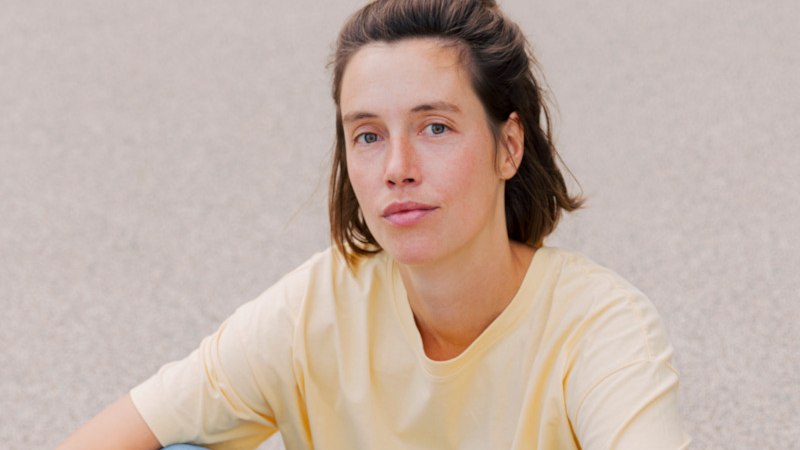 Eine Frau mit braunen Haaren in einem gelben T-Shirt sitzt vor einem grauen Hintergrund., © Kulturamt der Stadt Esslingen am Neckar Eine Frau mit braunen Haaren in einem gelben T-Shirt sitzt vor einem grauen Hintergrund., © Kulturamt der Stadt Esslingen am Neckar