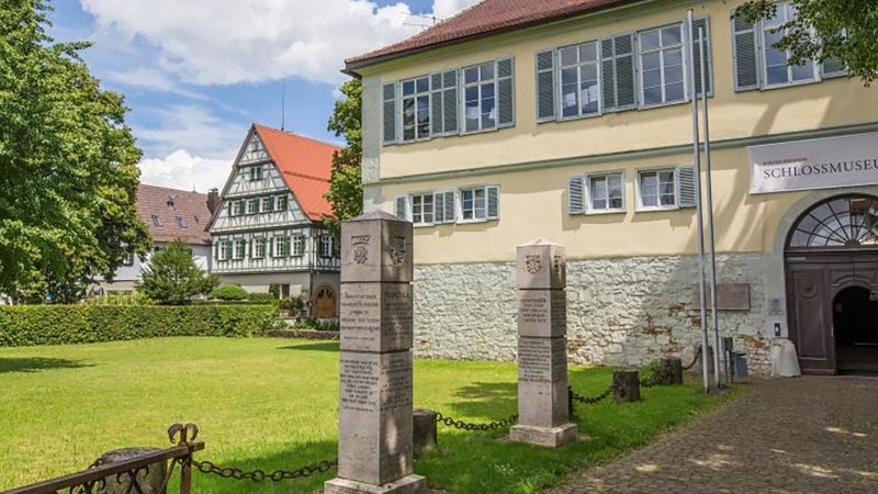 Eingang des Schlossmuseums in Kirchheim unter Teck, mit einem Fachwerkhaus im Hintergrund und einer grünen Wiese im Vordergrund., © Torsten Wenzler Eingang des Schlossmuseums in Kirchheim unter Teck, mit einem Fachwerkhaus im Hintergrund und einer grünen Wiese im Vordergrund., © Torsten Wenzler
