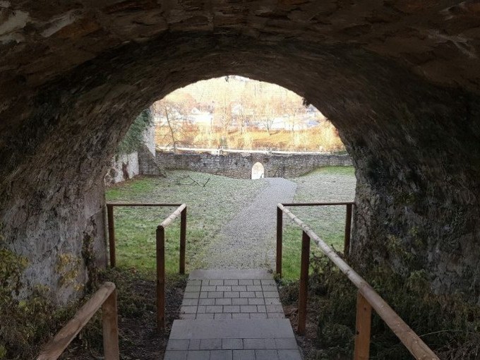 Steinerner Torbogen mit Blick auf gepflasterten Weg und Mauer im Hintergrund, umgeben von winterlicher Vegetation., &copy; Cool-Tours StattReisen