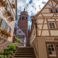 Fachwerkhäuser in der Keplergasse, Weil der Stadt. Das Keplermuseum ist sichtbar, mit einem Kirchturm im Hintergrund und blühenden Blumen an den Fenstern., © SMG, Achim Mende