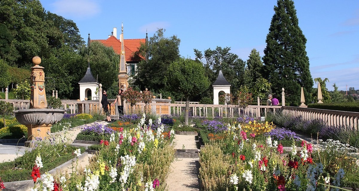 Der Pomeranzengarten Leonberg zeigt bunte Blumenbeete, historische Gebäude und eine dekorative Brunnenanlage unter blauem Himmel., © Landratsamt Böblingen Der Pomeranzengarten Leonberg zeigt bunte Blumenbeete, historische Gebäude und eine dekorative Brunnenanlage unter blauem Himmel., © Landratsamt Böblingen