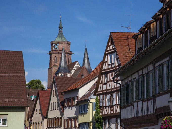 Fachwerkh&auml;user reihen sich in einer malerischen Altstadt aneinander. Im Hintergrund ragt ein Kirchturm in den blauen Himmel., &copy; Stadtverwaltung Weil der Stadt