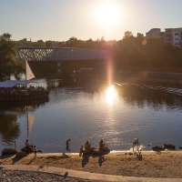 Sonnenuntergang am Neckarstrand in Remseck. Menschen entspannen am sandigen Ufer, während ein Schiff den Fluss passiert. Die Sonne spiegelt sich im Wasser., © Stuttgart-Marketing GmbH, Achim Mende