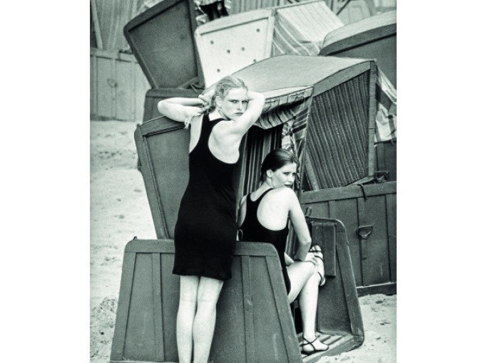 Zwei Frauen in schwarzen Badeanz&uuml;gen posieren in und vor Strandk&ouml;rben an einem Strand. Die Szene wirkt nostalgisch und zeitlos., &copy; Kunsthalle G&ouml;ppingen