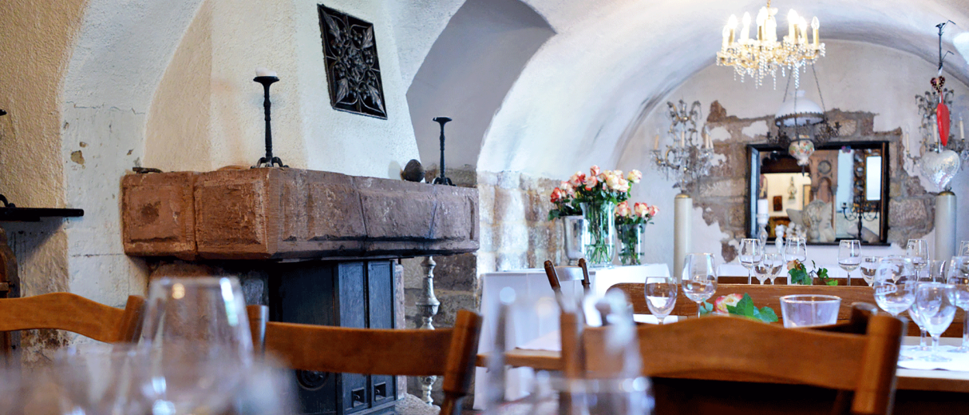 Eleganter Gastraum mit gewölbter Decke, Kamin, Kronleuchter und gedeckten Tischen. Blumenarrangements und Spiegel im Hintergrund., © FreCla Gastronomiebetriebe GmbH Eleganter Gastraum mit gewölbter Decke, Kamin, Kronleuchter und gedeckten Tischen. Blumenarrangements und Spiegel im Hintergrund., © FreCla Gastronomiebetriebe GmbH
