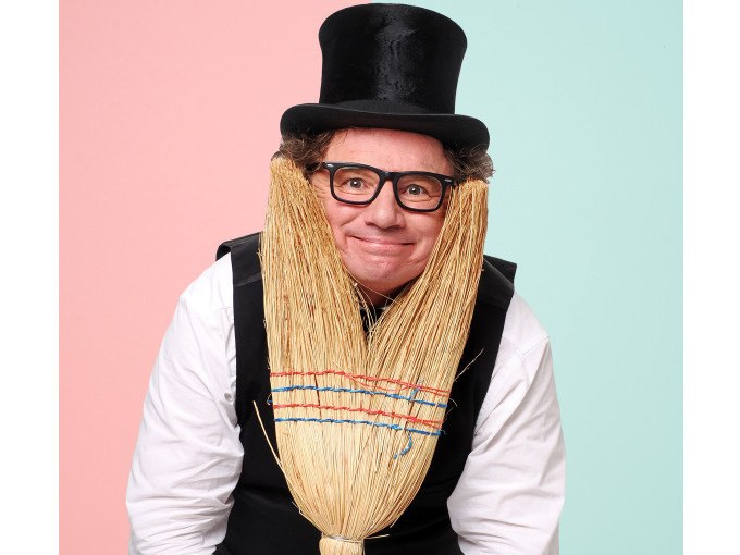 Ein Mann mit Zylinder und Brille posiert mit einem Besen, der wie ein Bart aussieht, vor einem zweifarbigen Hintergrund., © Stadt Murrhardt Ein Mann mit Zylinder und Brille posiert mit einem Besen, der wie ein Bart aussieht, vor einem zweifarbigen Hintergrund., © Stadt Murrhardt