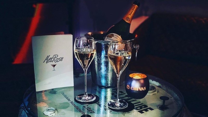 Tisch in der MelRose Bar mit Champagnergläsern, Flasche im Eiskübel und Kerze. Elegante Atmosphäre., © MelRose Bar