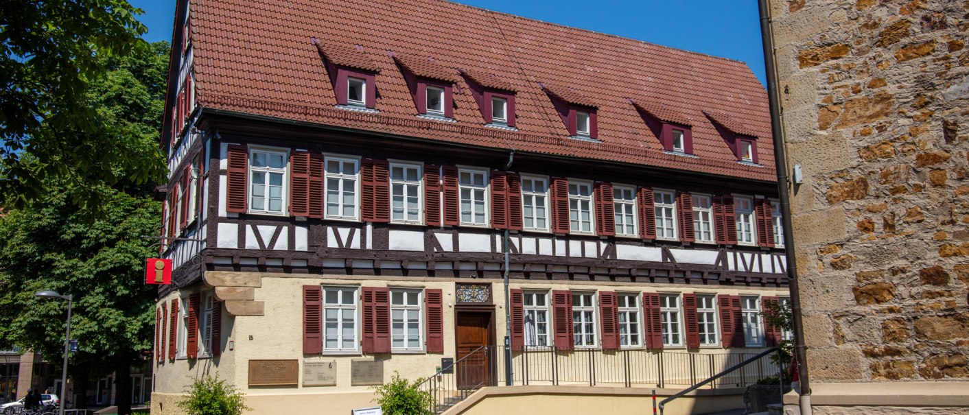 Fachwerkhaus mit rotem Dach und Tourist-Info-Schild. Vor dem Gebäude sitzt eine Person auf einer Bank. Blauer Himmel im Hintergrund., © Kirchheim unter Teck Fachwerkhaus mit rotem Dach und Tourist-Info-Schild. Vor dem Gebäude sitzt eine Person auf einer Bank. Blauer Himmel im Hintergrund., © Kirchheim unter Teck