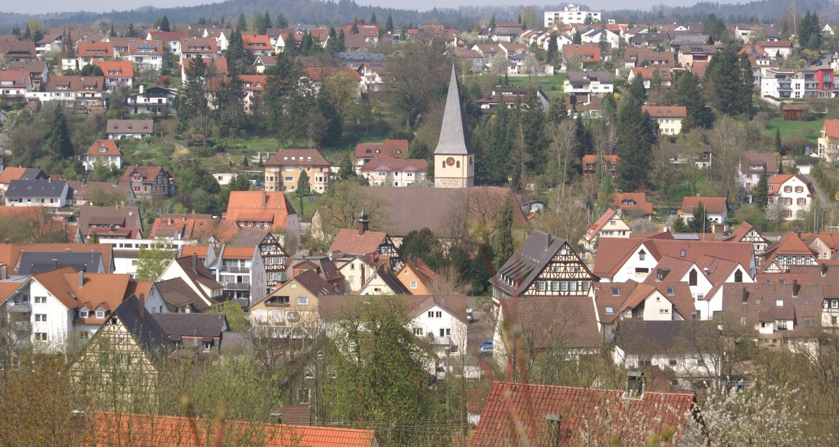 Panoramablick auf Lorch mit zahlreichen Häusern und einer zentralen Kirche. Die Dächer sind überwiegend rot, umgeben von Bäumen und Hügeln im Hintergrund., © Remstal Tourismus e.V.