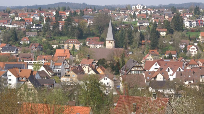 Panoramablick auf Lorch mit zahlreichen Häusern und einer zentralen Kirche. Die Dächer sind überwiegend rot, umgeben von Bäumen und Hügeln im Hintergrund., © Remstal Tourismus e.V.