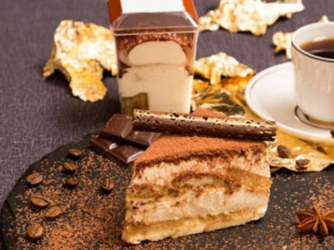 Ein Teller mit Tiramisu, Schokolade und einer Tasse Kaffee, dekoriert mit Kaffeebohnen und goldenen Blättern auf einem dunklen Tuch., © WTM GmbH Waiblingen Ein Teller mit Tiramisu, Schokolade und einer Tasse Kaffee, dekoriert mit Kaffeebohnen und goldenen Blättern auf einem dunklen Tuch., © WTM GmbH Waiblingen
