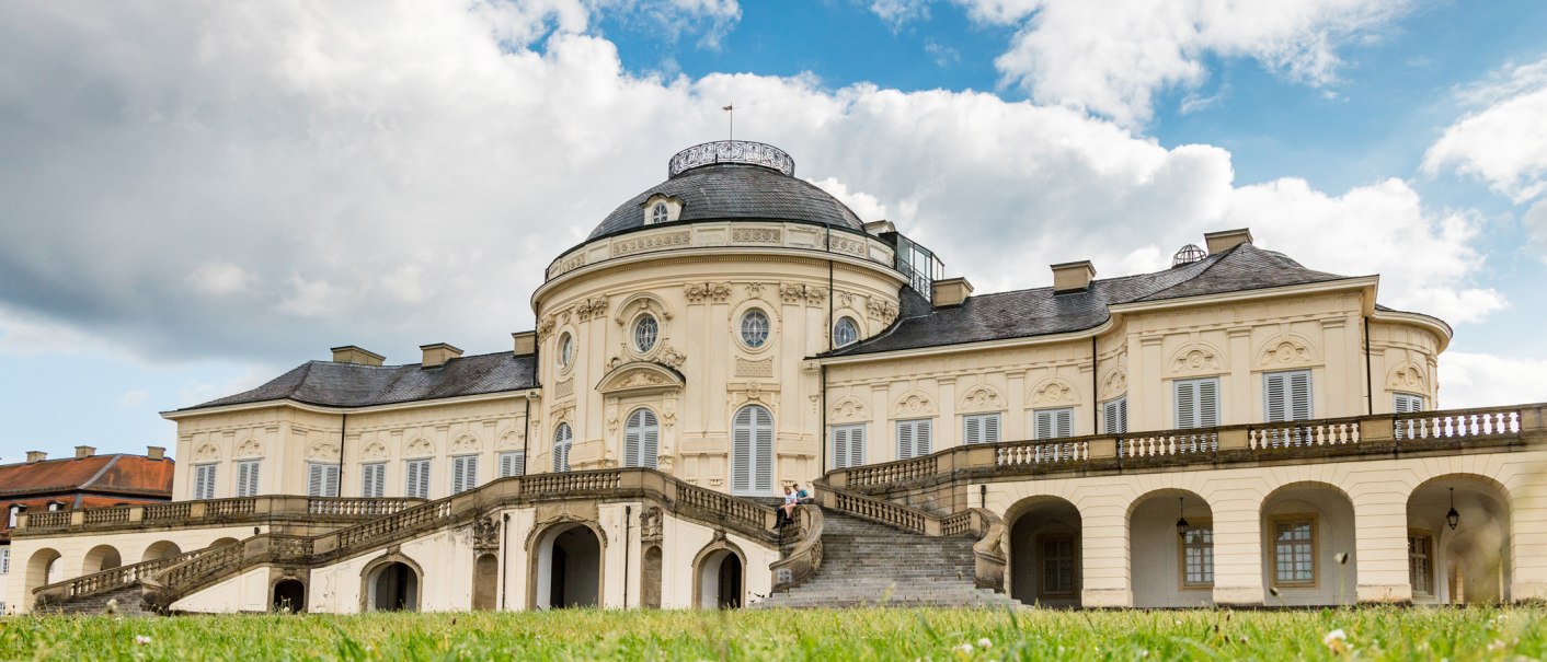 Schloss Solitude mit barocker Architektur, Treppenaufgang und grüner Wiese im Vordergrund. Der Himmel ist bewölkt., © Katrin Lehr (VIEL UNTERWEGS) Schloss Solitude mit barocker Architektur, Treppenaufgang und grüner Wiese im Vordergrund. Der Himmel ist bewölkt., © Katrin Lehr (VIEL UNTERWEGS)