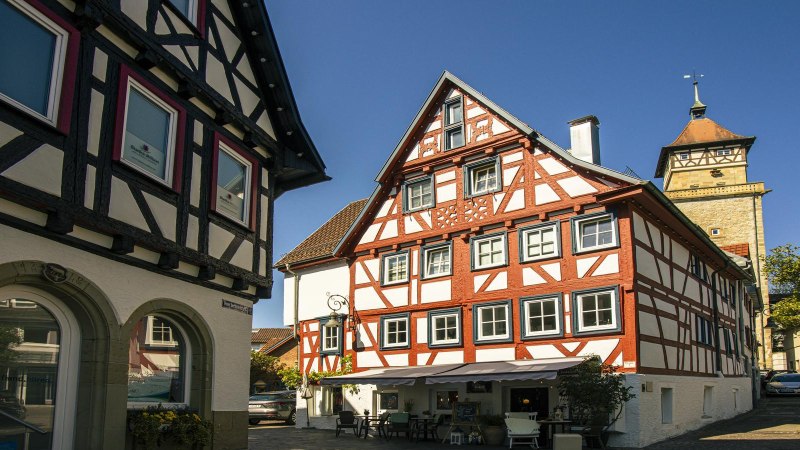 Fachwerkhäuser in der Altstadt von Waiblingen, Deutschland, bei sonnigem Wetter. Ein Turm ist im Hintergrund sichtbar., © SMG, Sarah Schmid