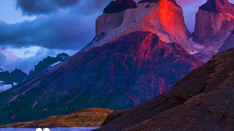 Majest&auml;tische Berge in S&uuml;damerika leuchten im Abendlicht, umgeben von dramatischen Wolken und einem flie&szlig;enden Fluss im Vordergrund., &copy; Expedition Erde