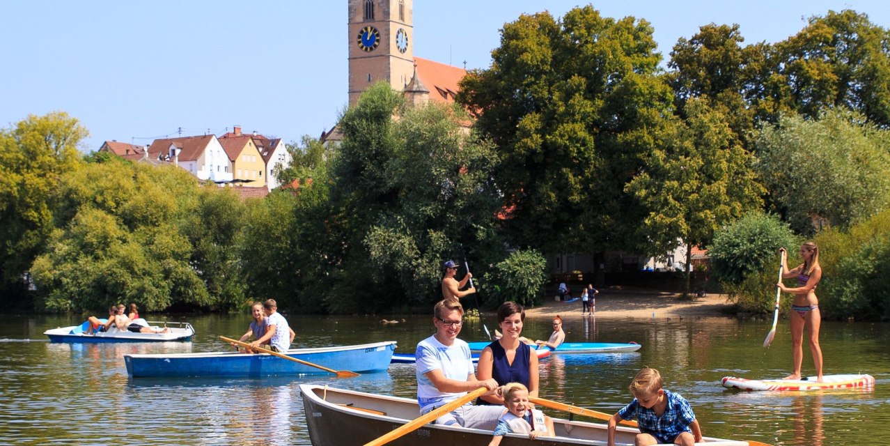 Familien und Freunde genießen eine Bootspartie auf einem See, während im Hintergrund ein Kirchturm zu sehen ist., © H. Bergmüller Familien und Freunde genießen eine Bootspartie auf einem See, während im Hintergrund ein Kirchturm zu sehen ist., © H. Bergmüller