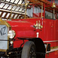 Ein rotes, historisches Feuerwehrfahrzeug mit der Aufschrift 'Benz' im Feuerwehrmuseum Winnenden, umgeben von Leitern und Ausstellungsstücken., © Stuttgart-Marketing GmbH