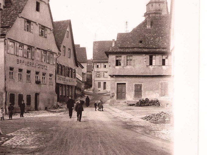 Historische Stra&szlig;enszene mit alten Fachwerkh&auml;usern, darunter eine Brauerei. Menschen spazieren auf der Stra&szlig;e in einem Dorf., &copy; Stadtverwaltung Weil der Stadt