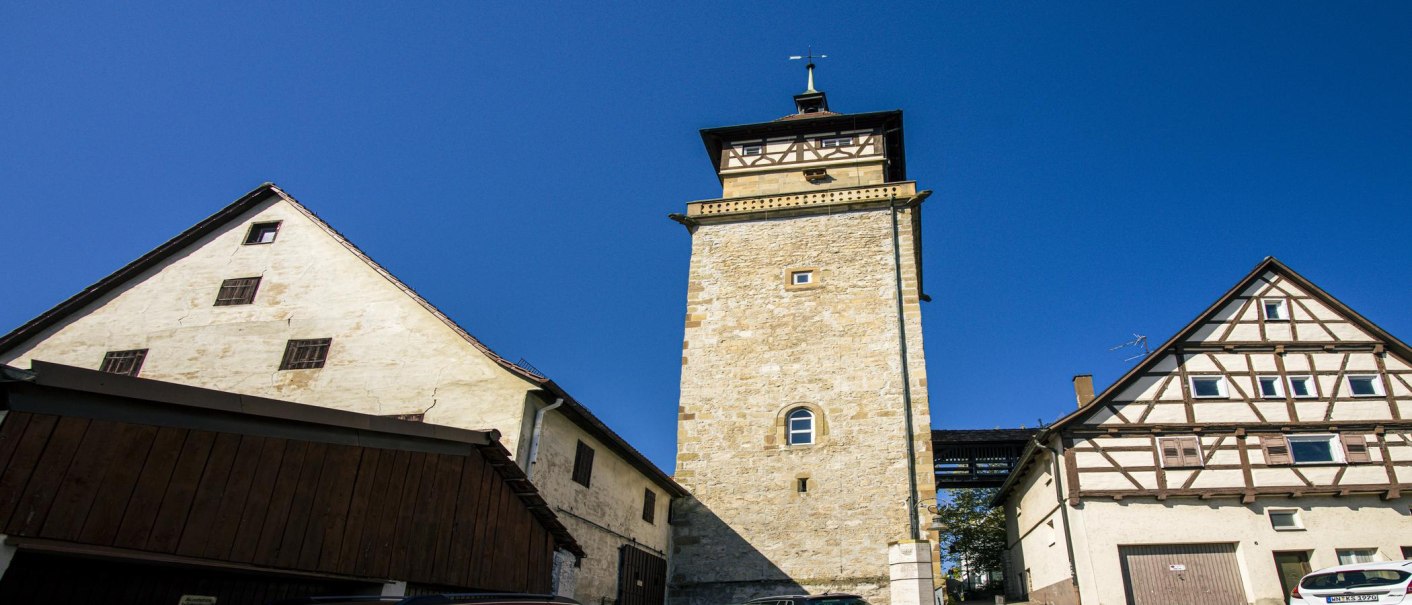 Der Hochwachturm in Waiblingen steht zwischen zwei Fachwerkhäusern unter klarem, blauem Himmel., © SMG, Sarah Schmid Der Hochwachturm in Waiblingen steht zwischen zwei Fachwerkhäusern unter klarem, blauem Himmel., © SMG, Sarah Schmid