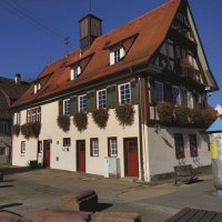 Historisches Rathaus in Ötlingen mit rotem Satteldach, Fachwerkdetails und Blumenkästen an den Fenstern. Sonniger Tag, blauer Himmel., © Stadt Kirchheim unter Teck