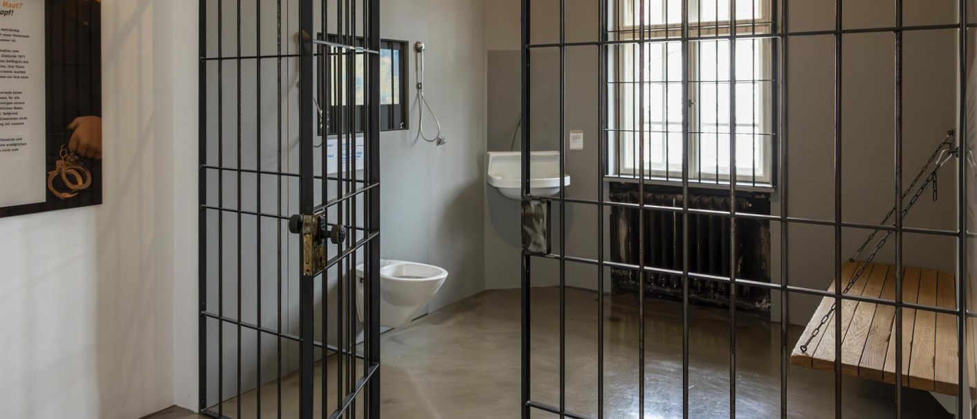 Eine Gefängniszelle in einer Ausstellung mit Bett, Waschbecken und Toilette. Die Zellentür steht offen., © Stuttgart-Marketing GmbH, Sarah Schmid Eine Gefängniszelle in einer Ausstellung mit Bett, Waschbecken und Toilette. Die Zellentür steht offen., © Stuttgart-Marketing GmbH, Sarah Schmid