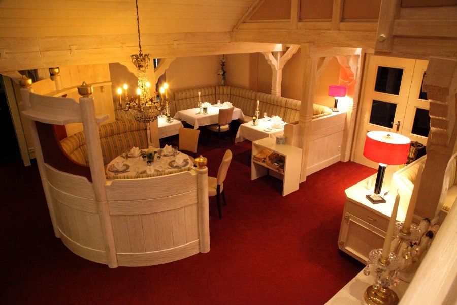 Elegantes Restaurant mit roten Teppichen, weißen Möbeln und einem Kronleuchter. Die Tische sind für Gäste gedeckt., © Hotel Fuchsen Elegantes Restaurant mit roten Teppichen, weißen Möbeln und einem Kronleuchter. Die Tische sind für Gäste gedeckt., © Hotel Fuchsen