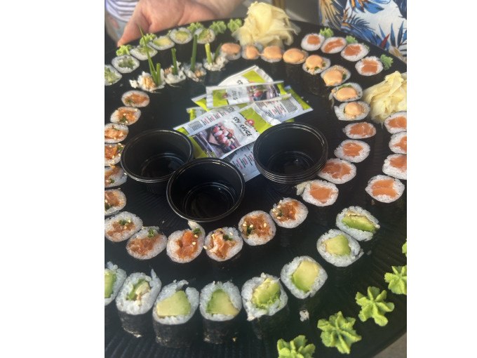 Ein großer Teller mit verschiedenen Sushi-Rollen, Sojasoße in kleinen Schalen und Wasabi. Im Hintergrund sind Hände und ein buntes Hemd zu sehen., © Cool-Tours StattReisen Ein großer Teller mit verschiedenen Sushi-Rollen, Sojasoße in kleinen Schalen und Wasabi. Im Hintergrund sind Hände und ein buntes Hemd zu sehen., © Cool-Tours StattReisen