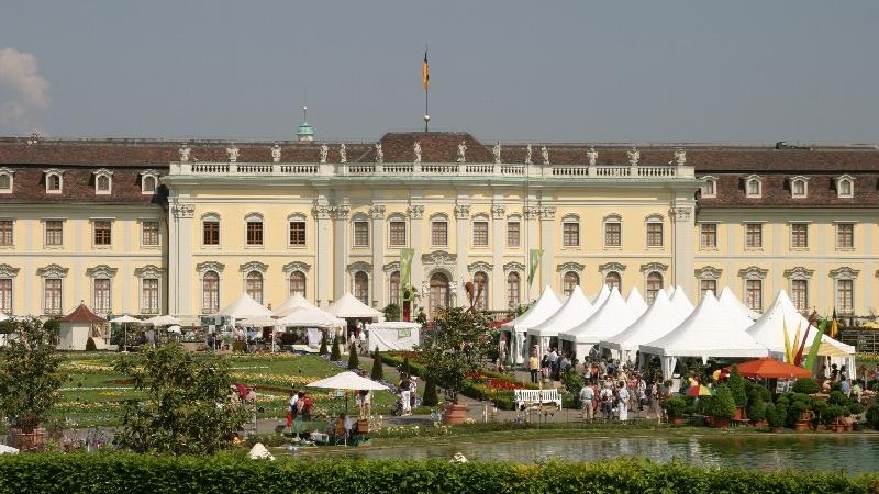 Ein barockes Schloss mit wei&szlig;en Zelten und Menschen im Garten. Die Szene zeigt eine Veranstaltung mit Besuchern und dekorativen Pflanzen., &copy; copyright: Marc Sansone