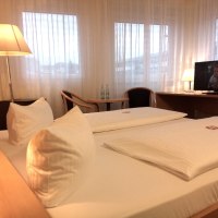 Gemütliches Doppelzimmer mit Doppelbett, Schreibtisch, Stuhl und Fernseher. Große Fenster mit Vorhängen., © Central Hotel