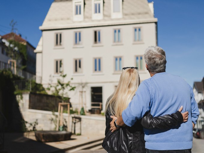 Ein &auml;lteres Paar umarmt sich und betrachtet ein modernes Geb&auml;ude bei sonnigem Wetter., &copy; Stadt N&uuml;rtingen